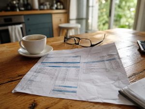 Avis de taxe foncière posé sur une table avec des lunettes et un café