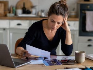 Femme calculant le budget réel de sa reconversion professionnelle avec des documents sur la table