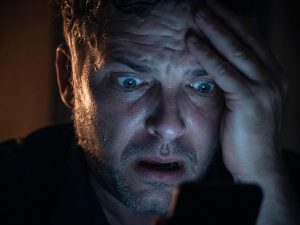 Homme sous le choc en découvrant la hausse de ses frais bancaires sur son téléphone