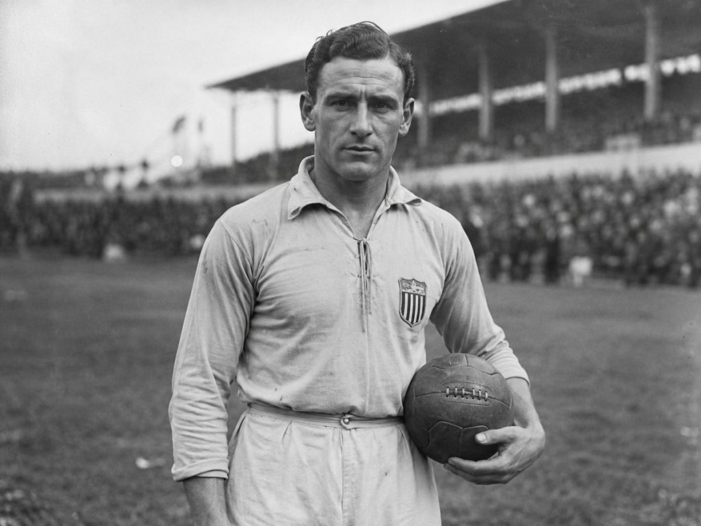 Footballeur en tenue d'époque sur un terrain avant un match lors de la Coupe du Monde de 1930
