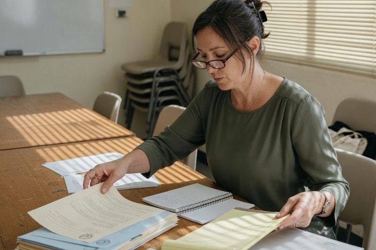 Femme organisant ses documents dans une salle de préparation au concours