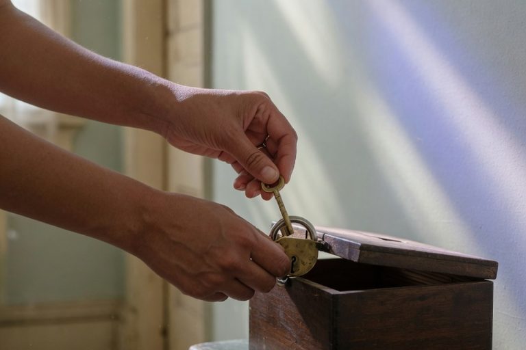 Mains verrouillant un coffre en bois dans un couloir lumineux