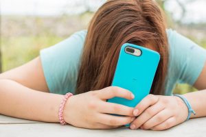Adolescente consultant son téléphone, carte bancaire pour les 12-17 ans